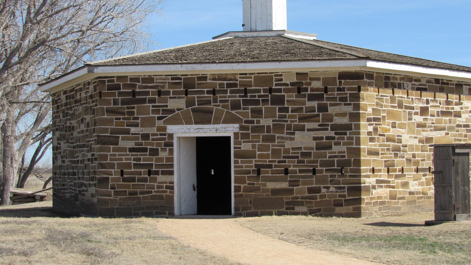Hexagonal one-story stone building with rifle slits instead of windows.