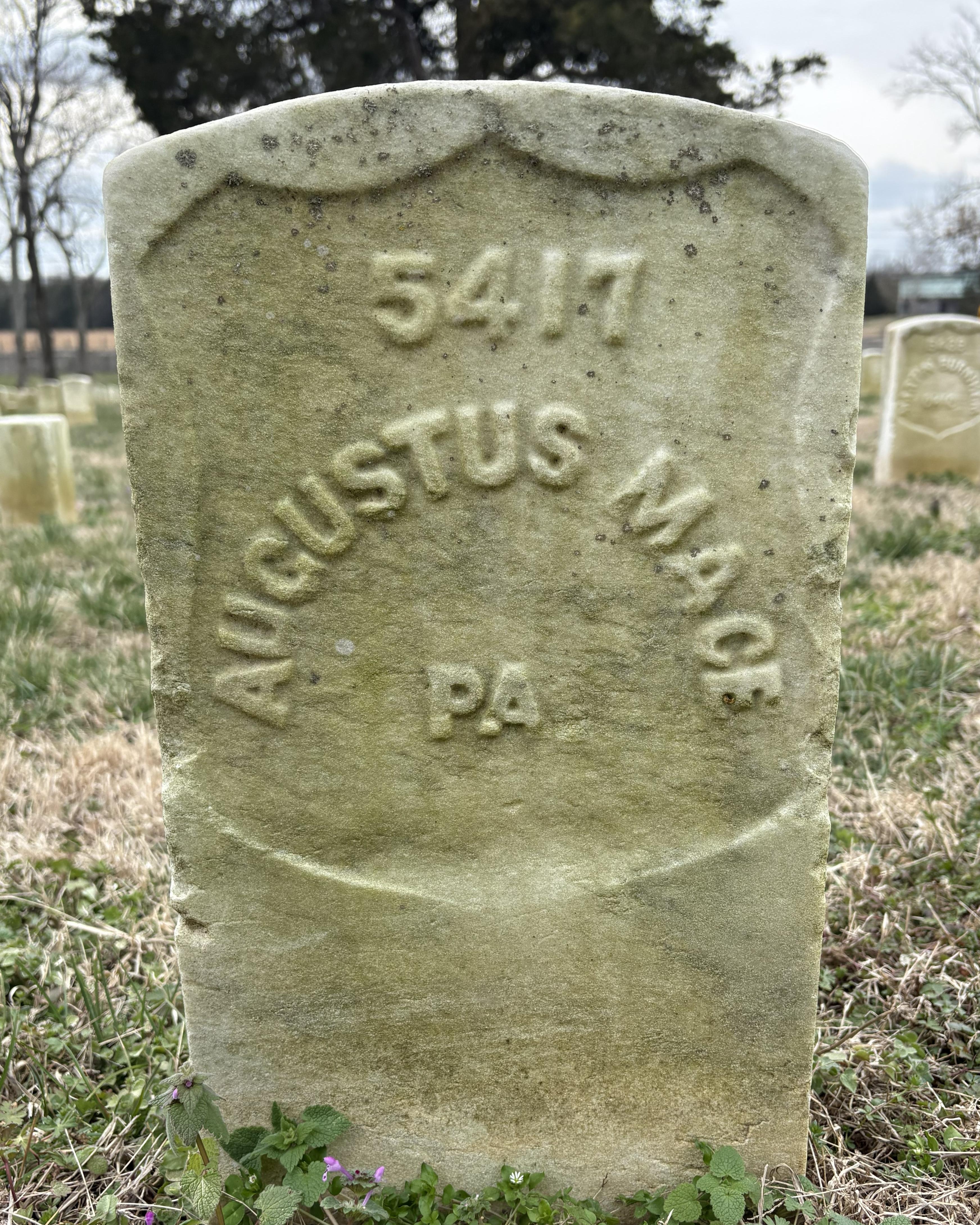 Marble headstone with "Augustus Mace PA" inscribed on it. 