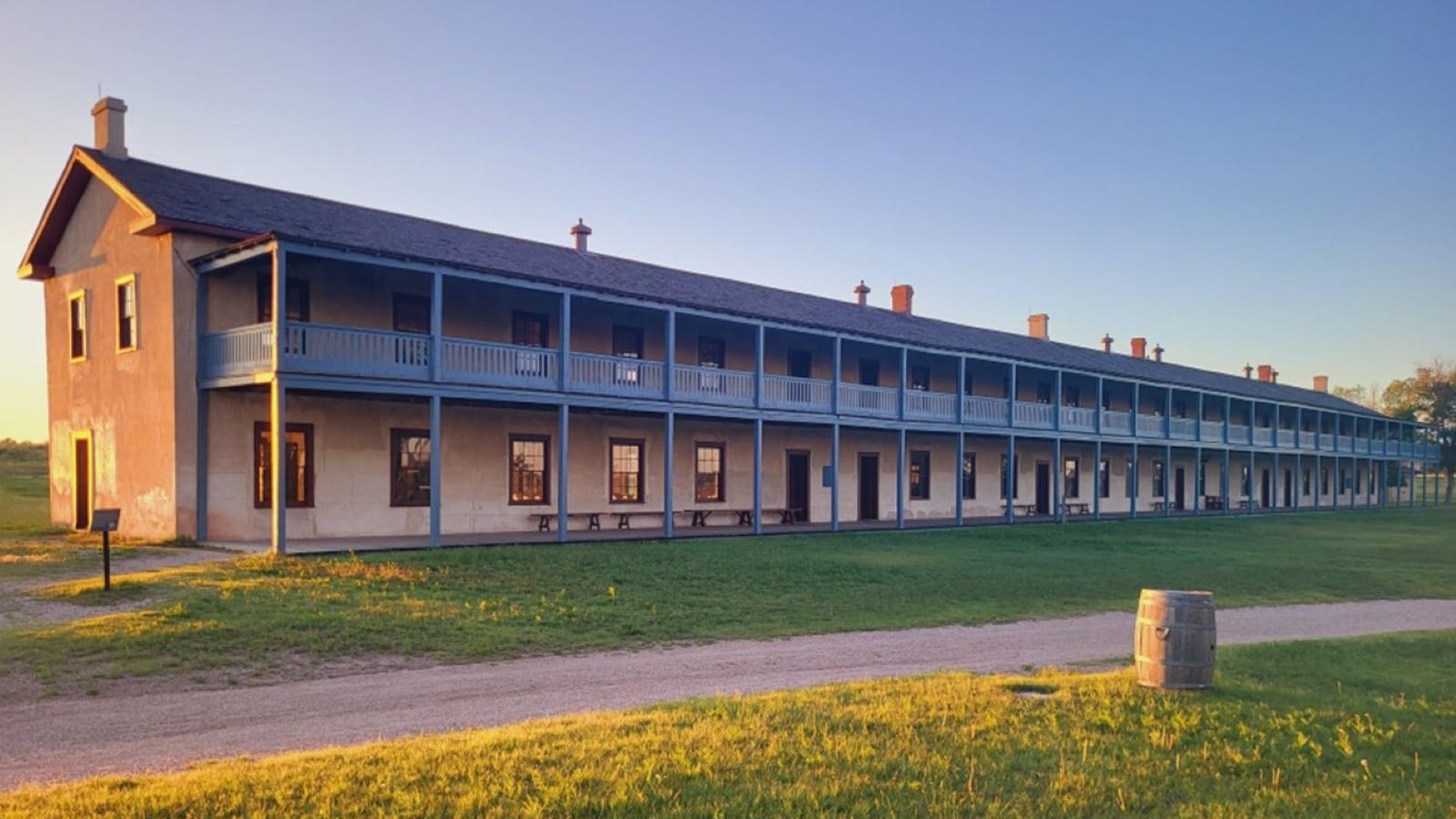 Long brown building with second floor blue porch.