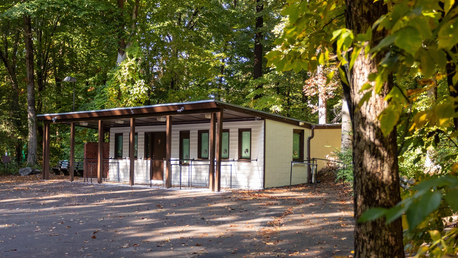 A small white building surrounded by trees. 