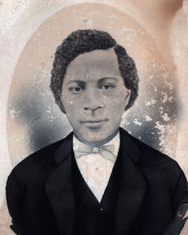 Portrait of a Black man wearing a suit with bowtie 