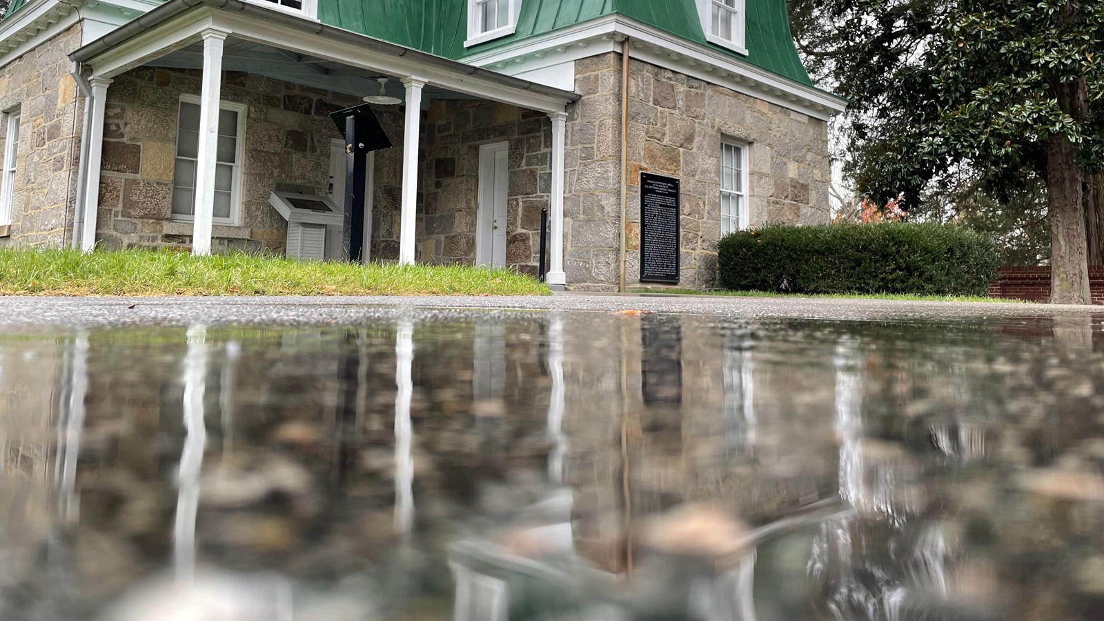 The superintendent\'s lodge with a reflection in a rain puddle.