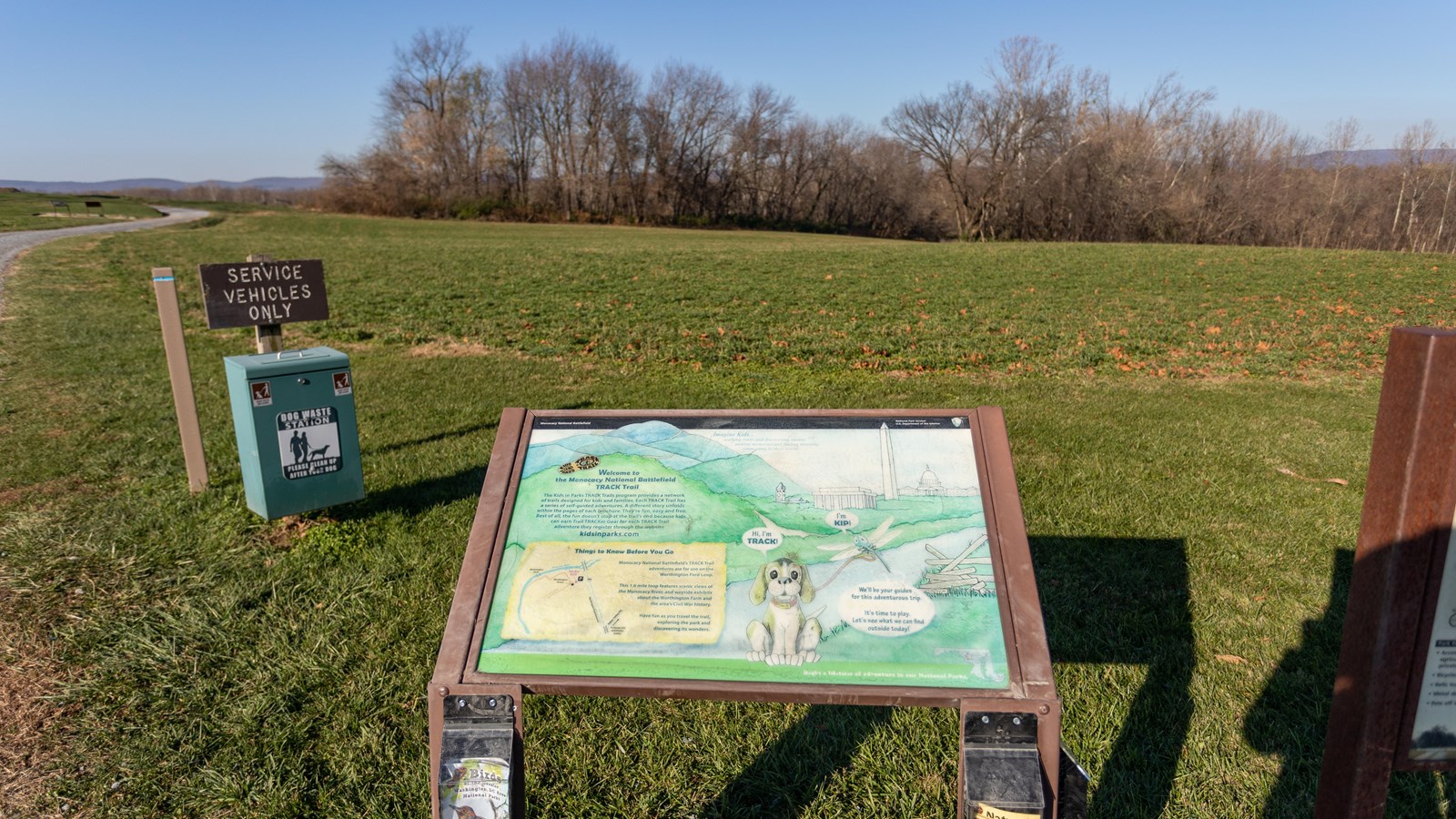 An informational panel in front of a large field. 
