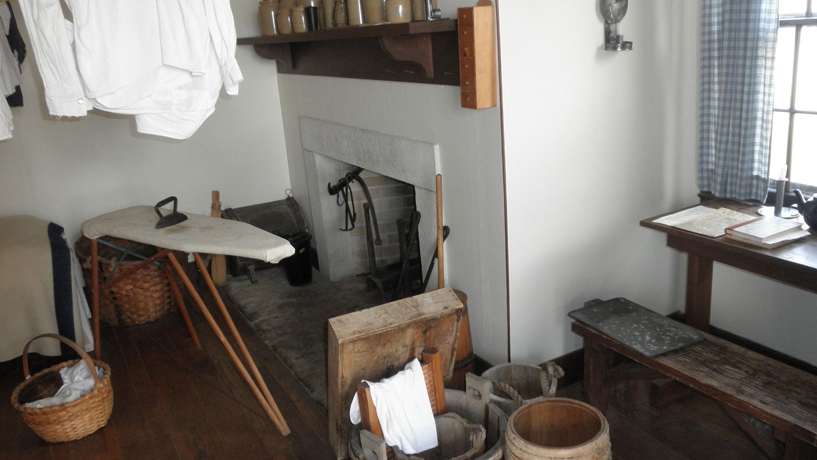 Fireplace and mantel in back with ironing board and washboard in front