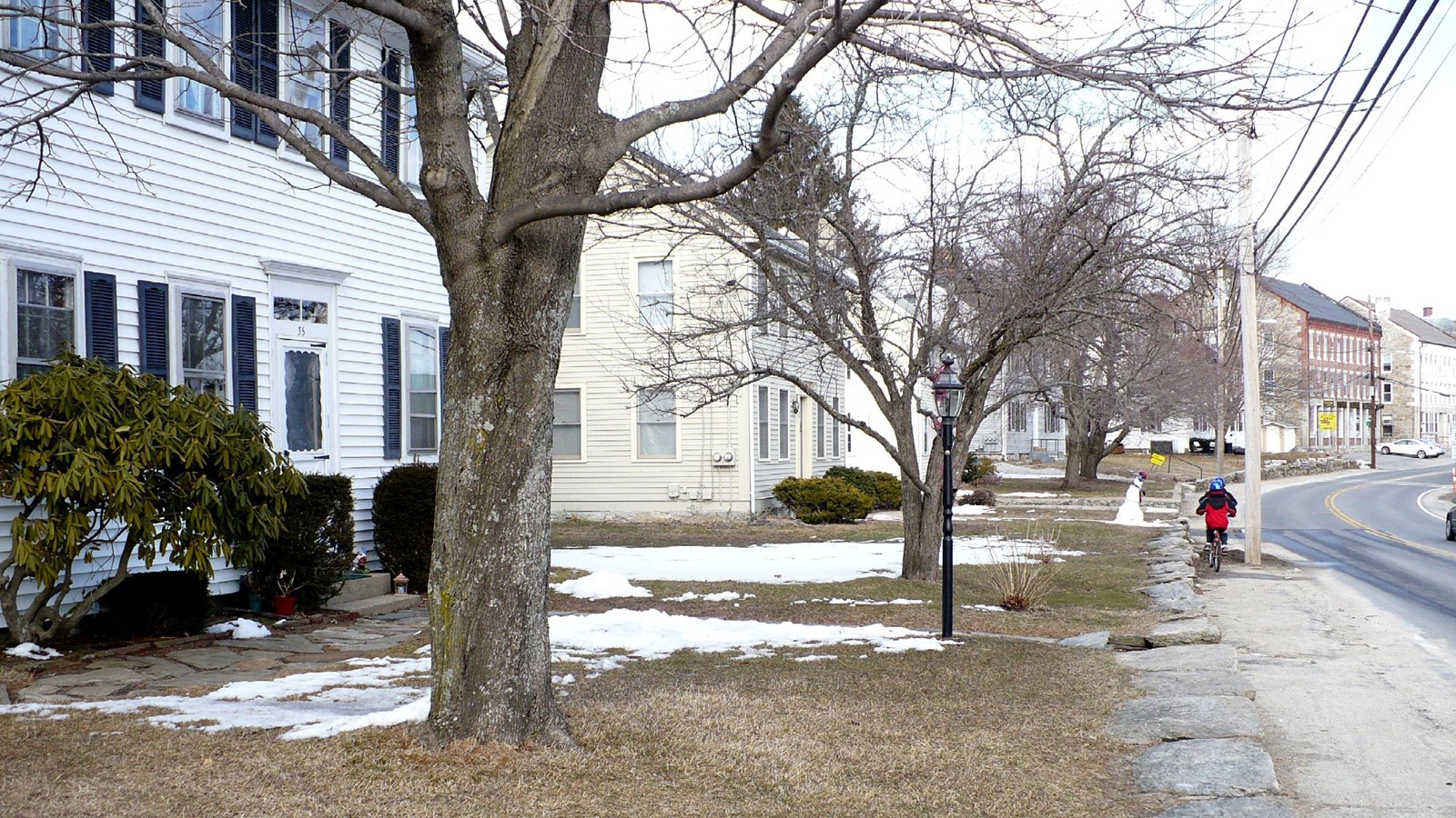 Several wooden houses along road with trees