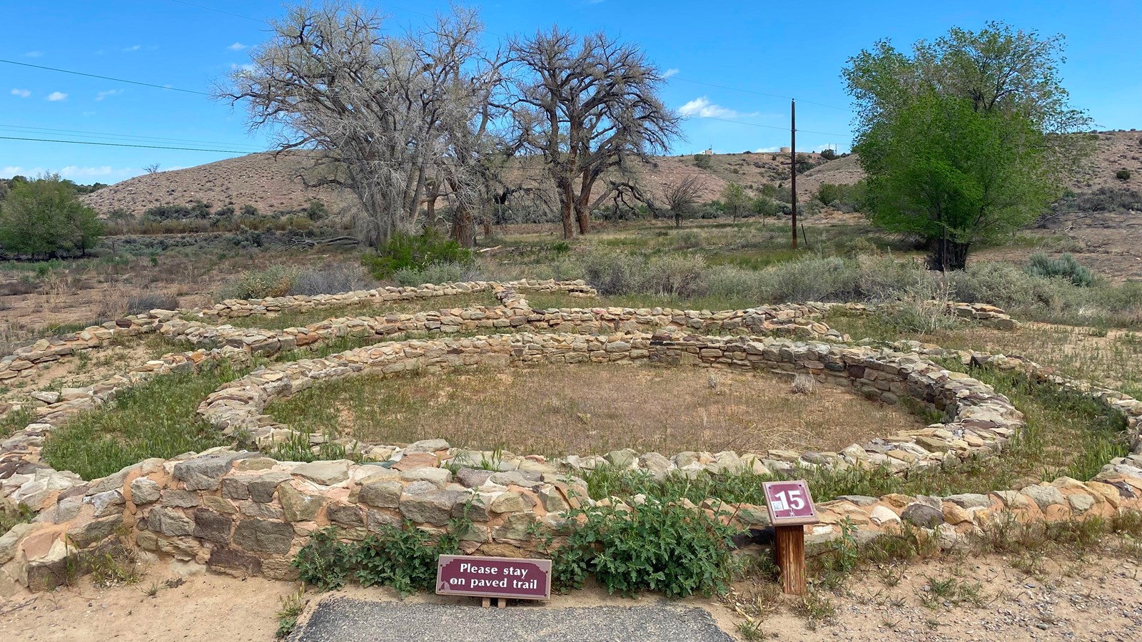 The top of a circle of sandstone blocks surrounded by three walls of concentric sandstone rooms.