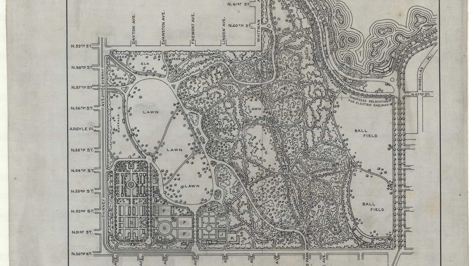 Plan of park between street grid roads with large open lawn, some buildings, curving paths and trees