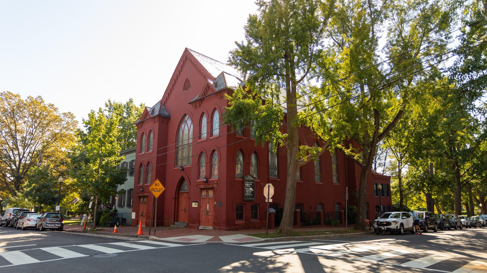 A large red church surrounded by trees. 