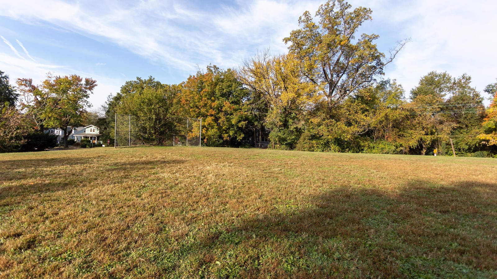 A large field surrounded by trees.
