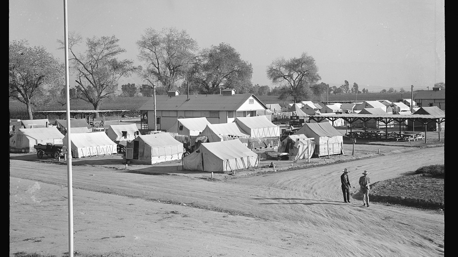 Black and white photo of white tents and dirt roads.