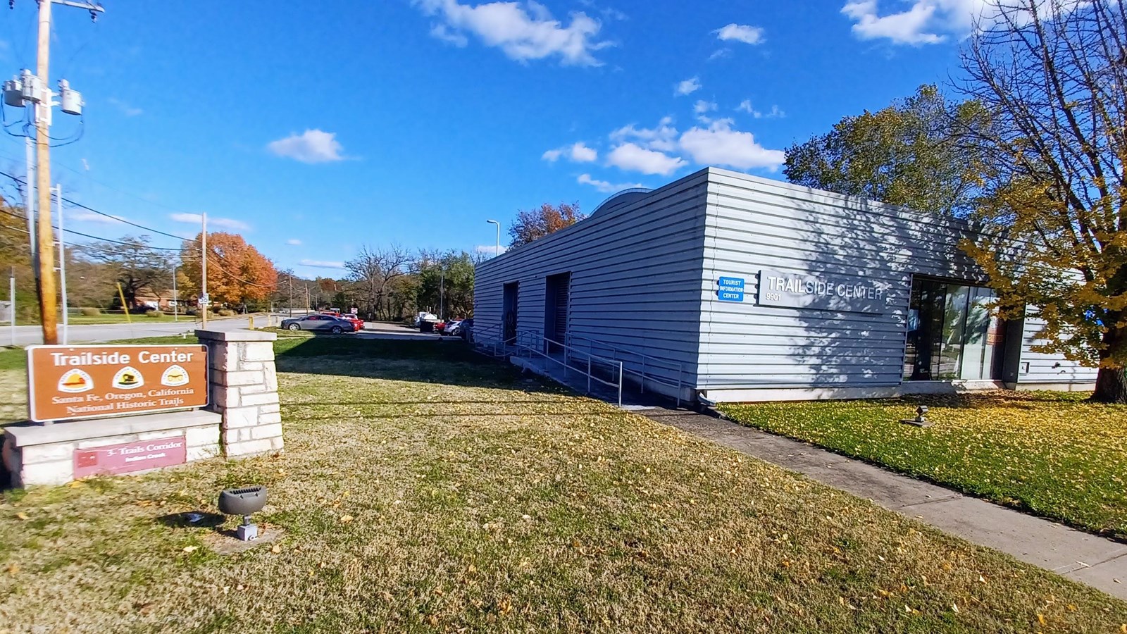 A large modern steel looking building with a large brown entry sign.