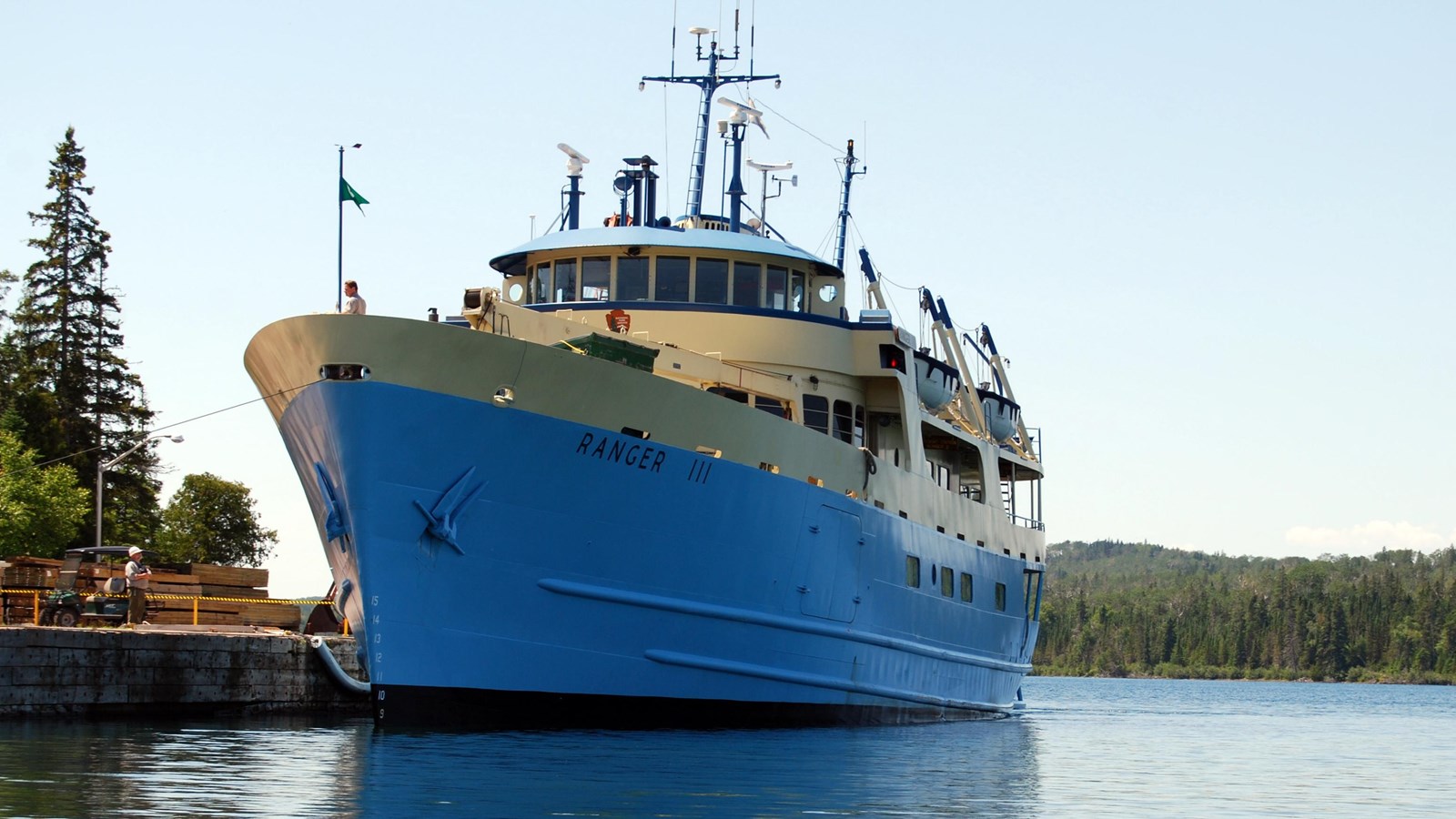 large blue and white cargo ship docked, with name \'RANGER III\' clearly visible on bow