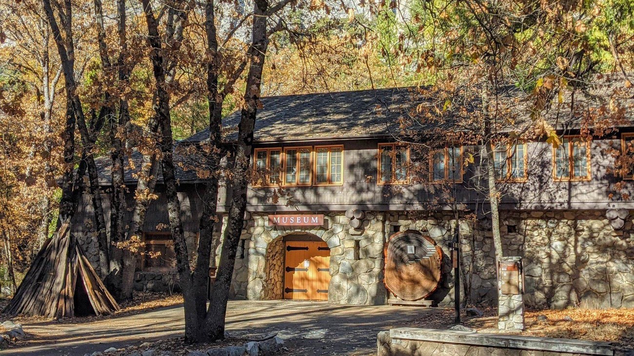 View of front of Yosemite Museum with dappled sunlight in fall.