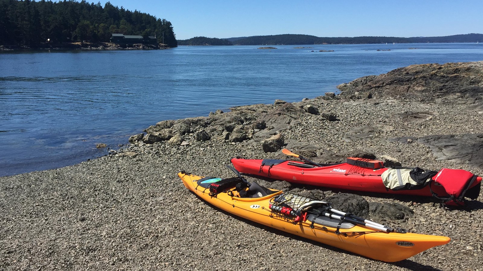Color photograph of two sea kayaks beached on an island