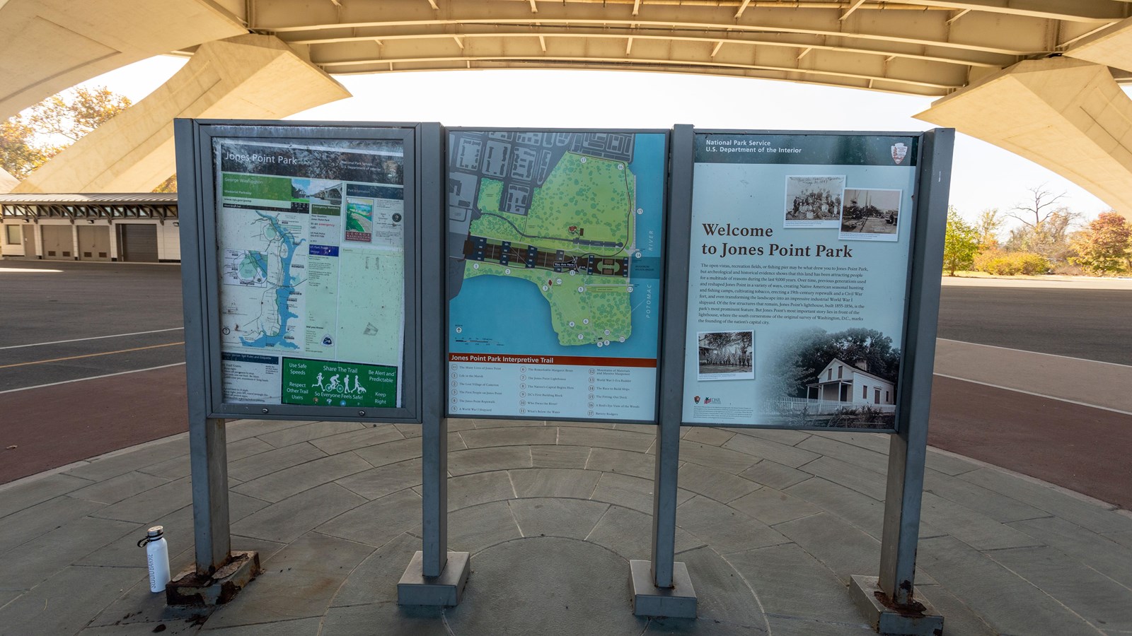 Three information panels under a bridge.