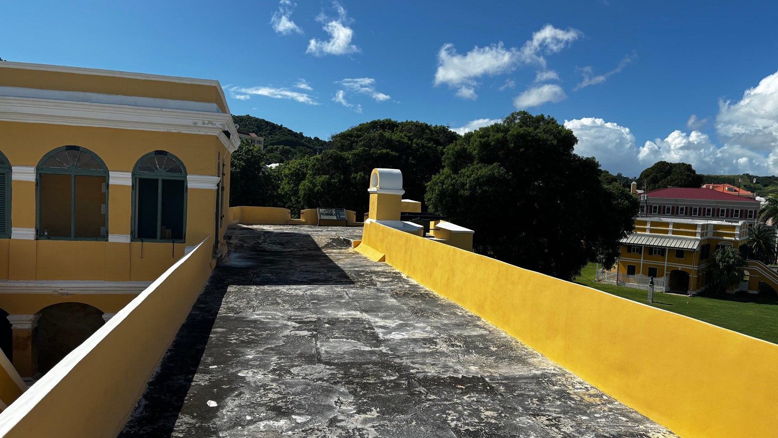 photo of a walkway leading toward the upper rooms of the fort. Mountains in the distance.