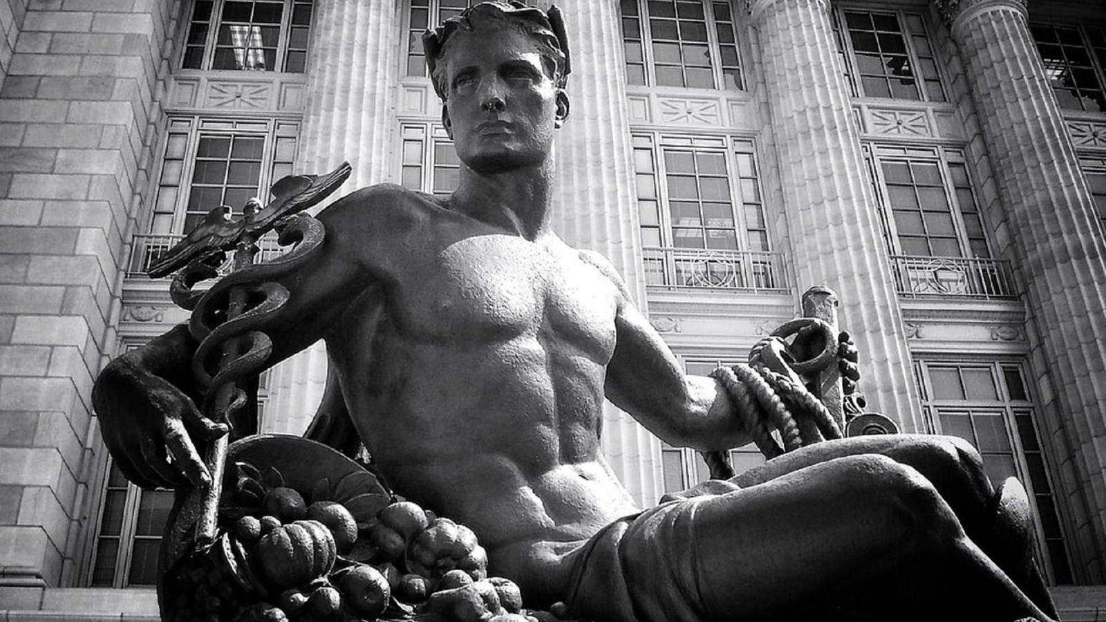 Statue of a man with a cornucopia, a caduceus, and a rope