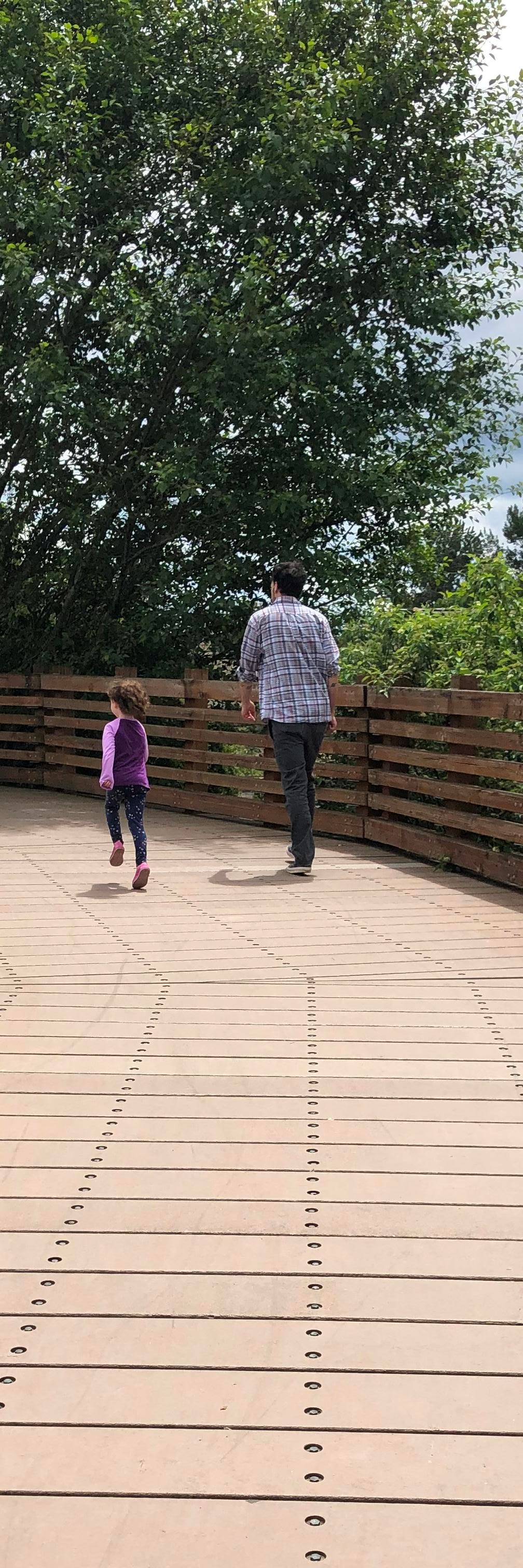 A man and child walk on a trail.