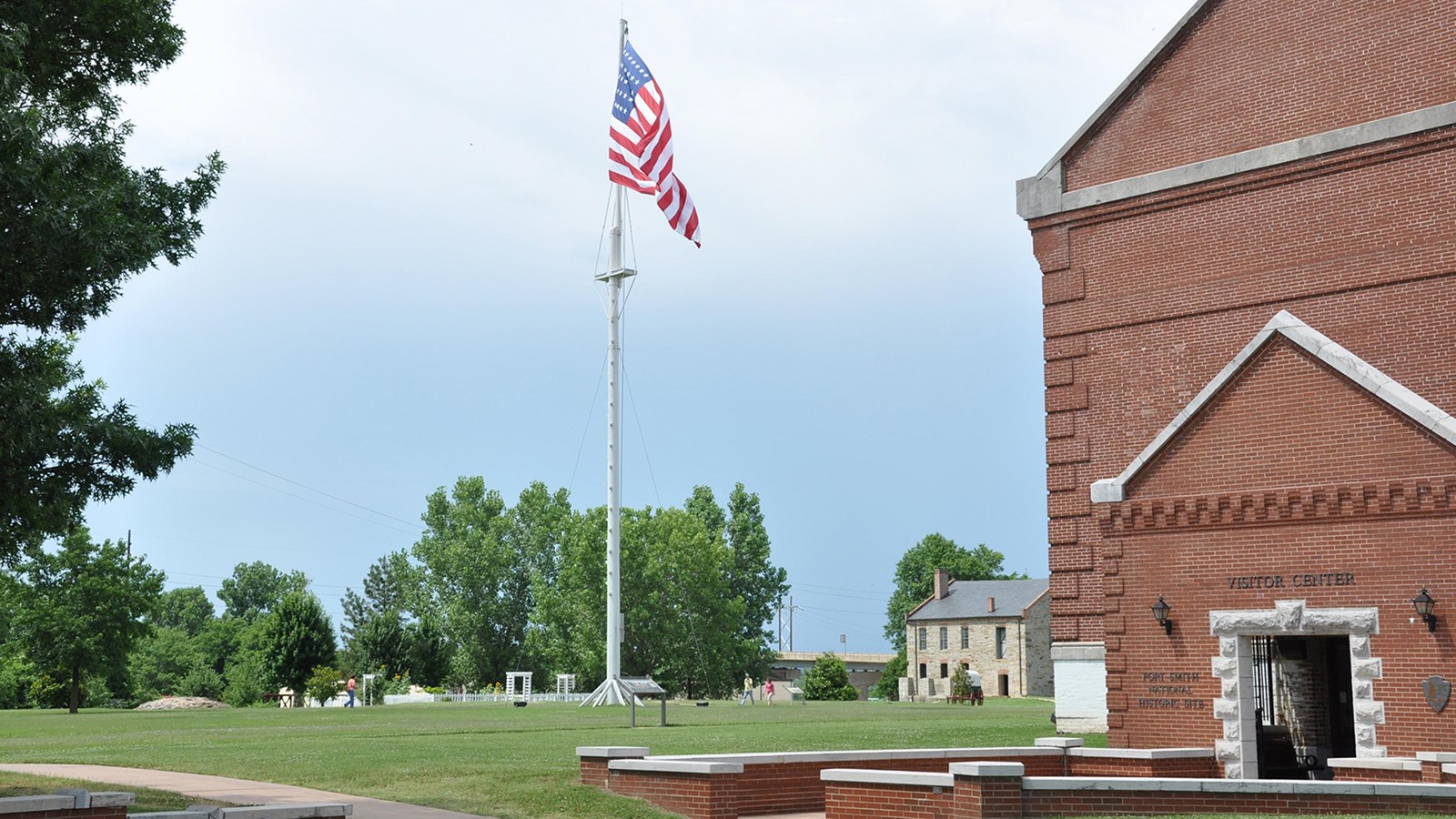 In the center of the image a large 37 star flag flies on a 100 foot tall flag pole to the right is t