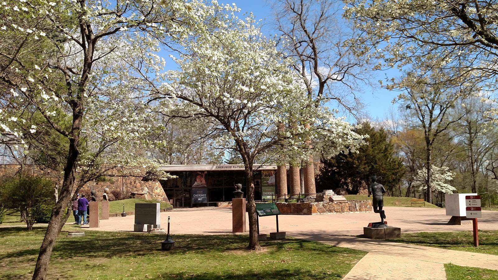 A sidewalk path with trees leading to the entrance to Cherokee Heritage Center