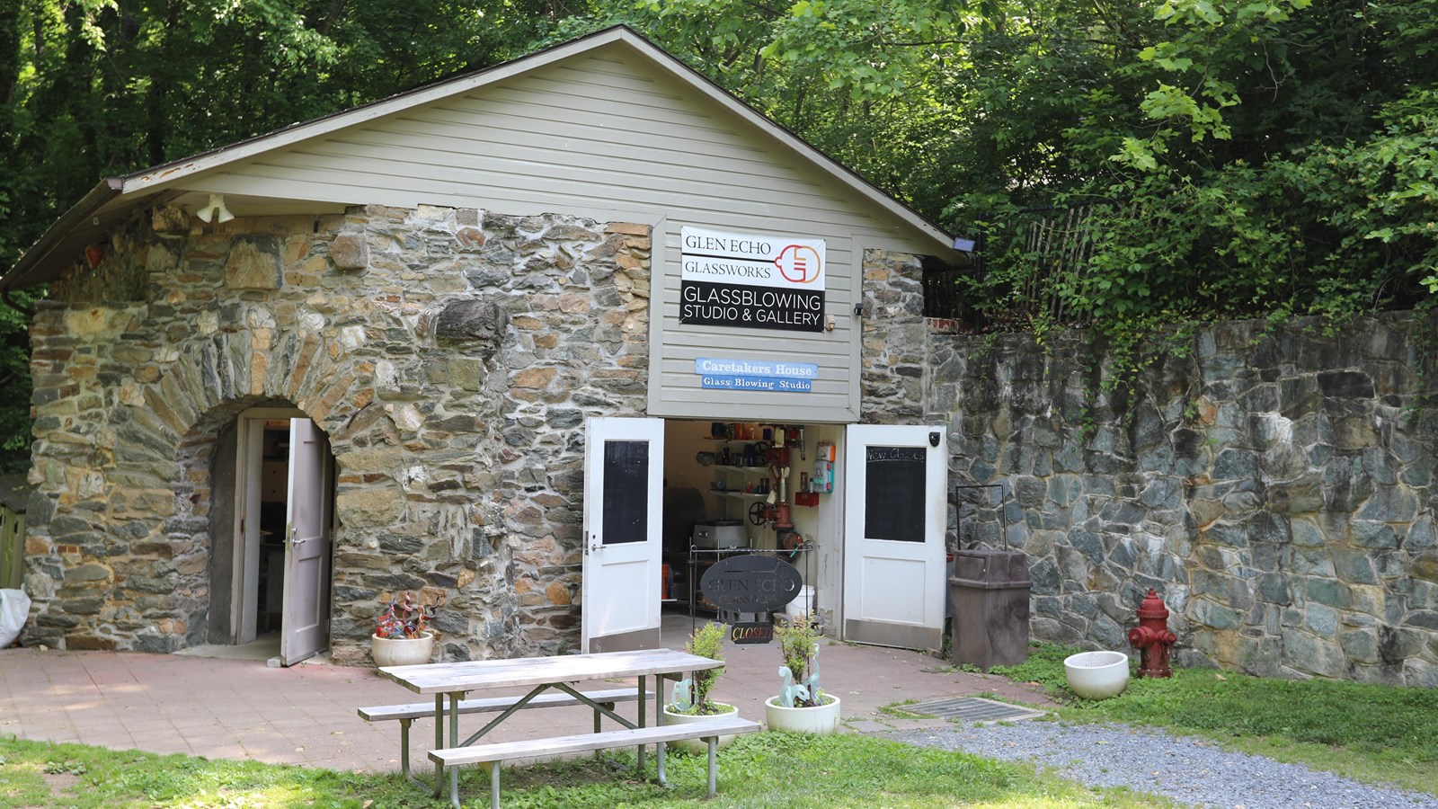 A paved path leads to a stone building labeled Glen Echo Glassworks Glassblowing Studio and Gallery