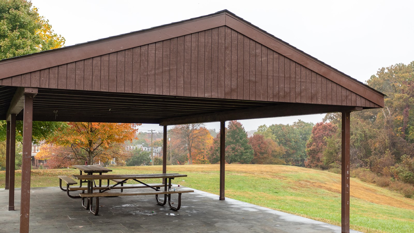 A gazebo picnic area surrounded by a field.