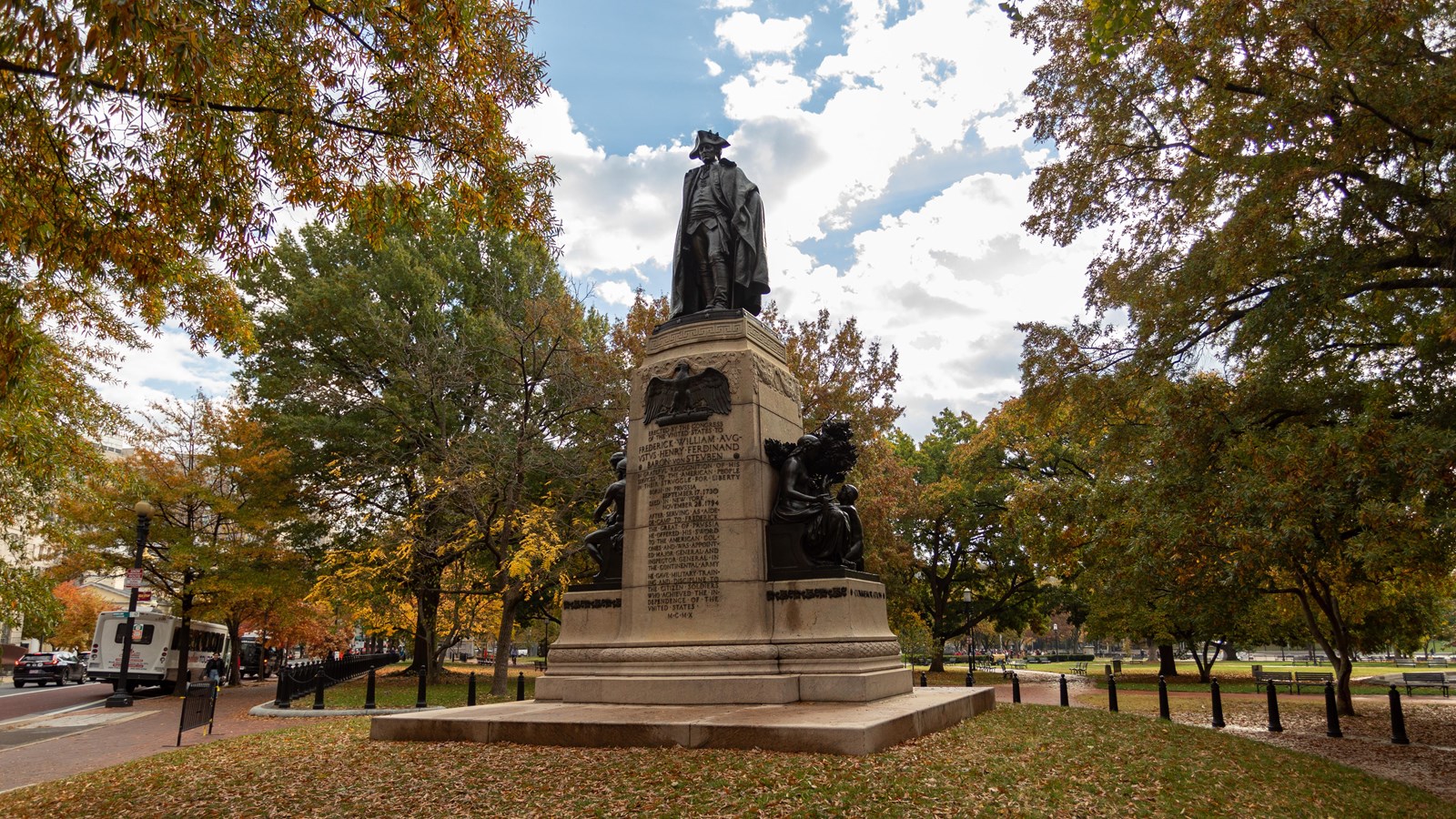 Bronze statue of a man in winter army uniform on a stone plinth.