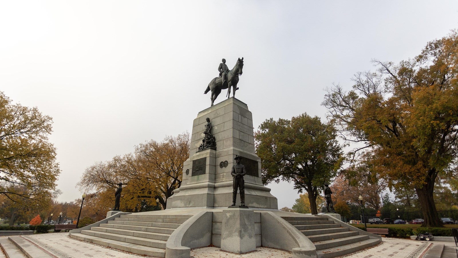 A statue of General William Tecumseh Sherman riding a horse on top of a large stone pedestal.