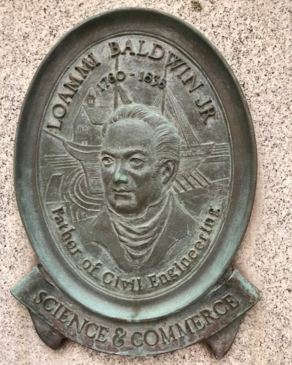 Round bronze plaque of a portrait of Baldwin Jr. with a ship behind his head and text with his name.