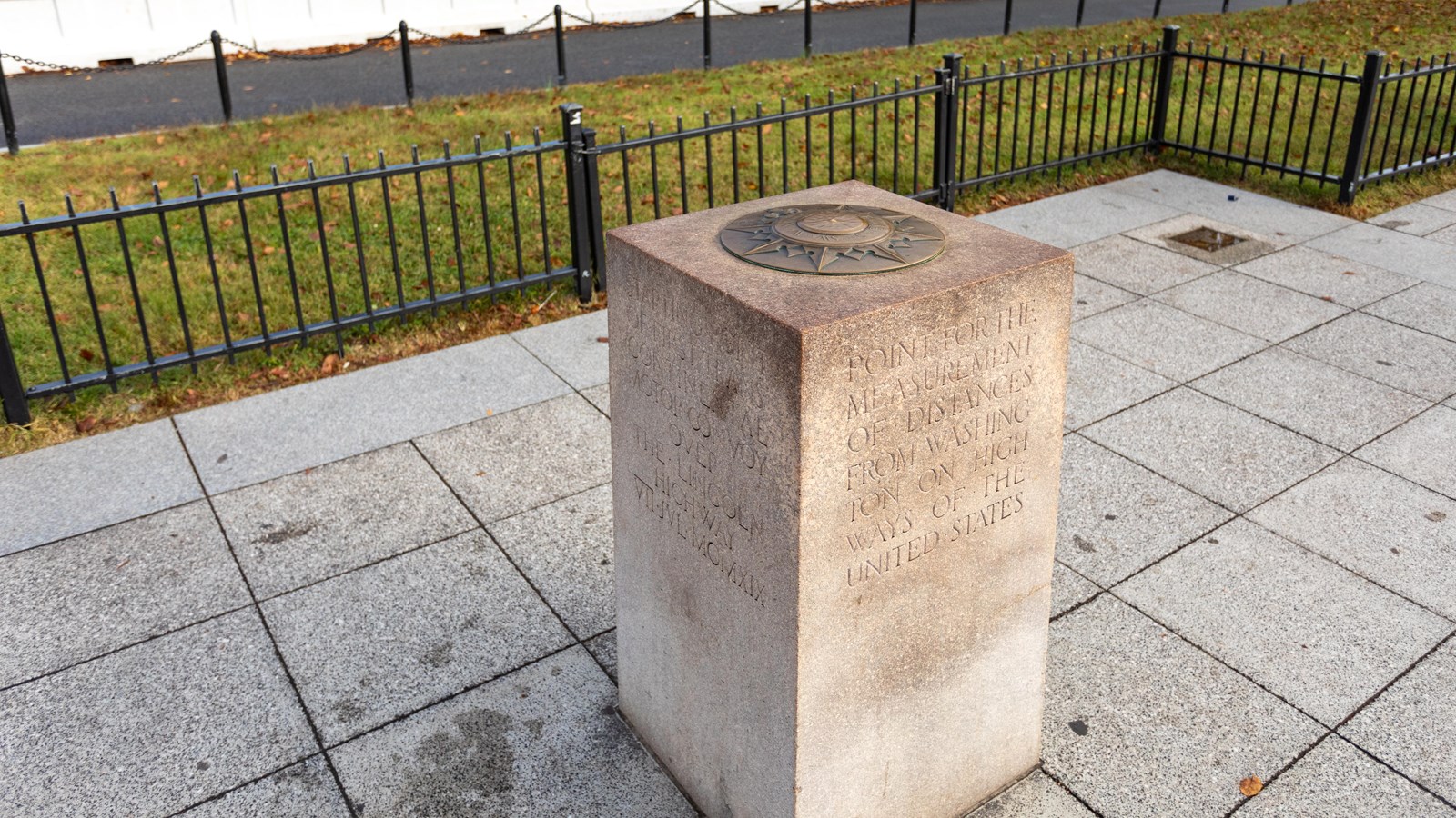 A granite monument with a bronze compass rose sitting on top.