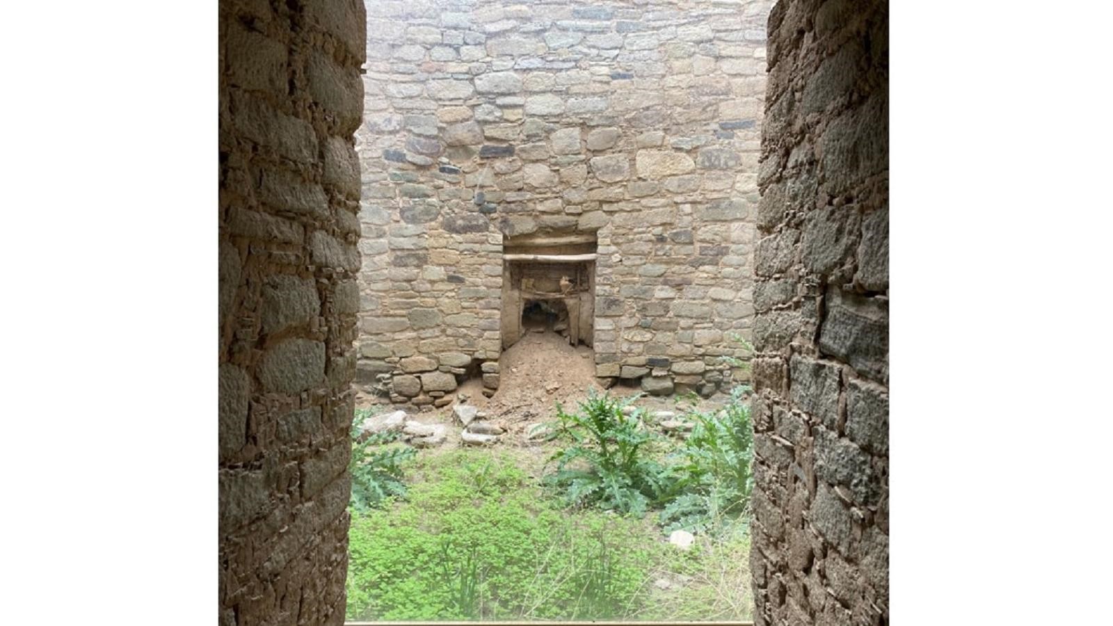 A plexiglass panel looking into another room showing a 900 year old yucca sewn mat over a doorway.