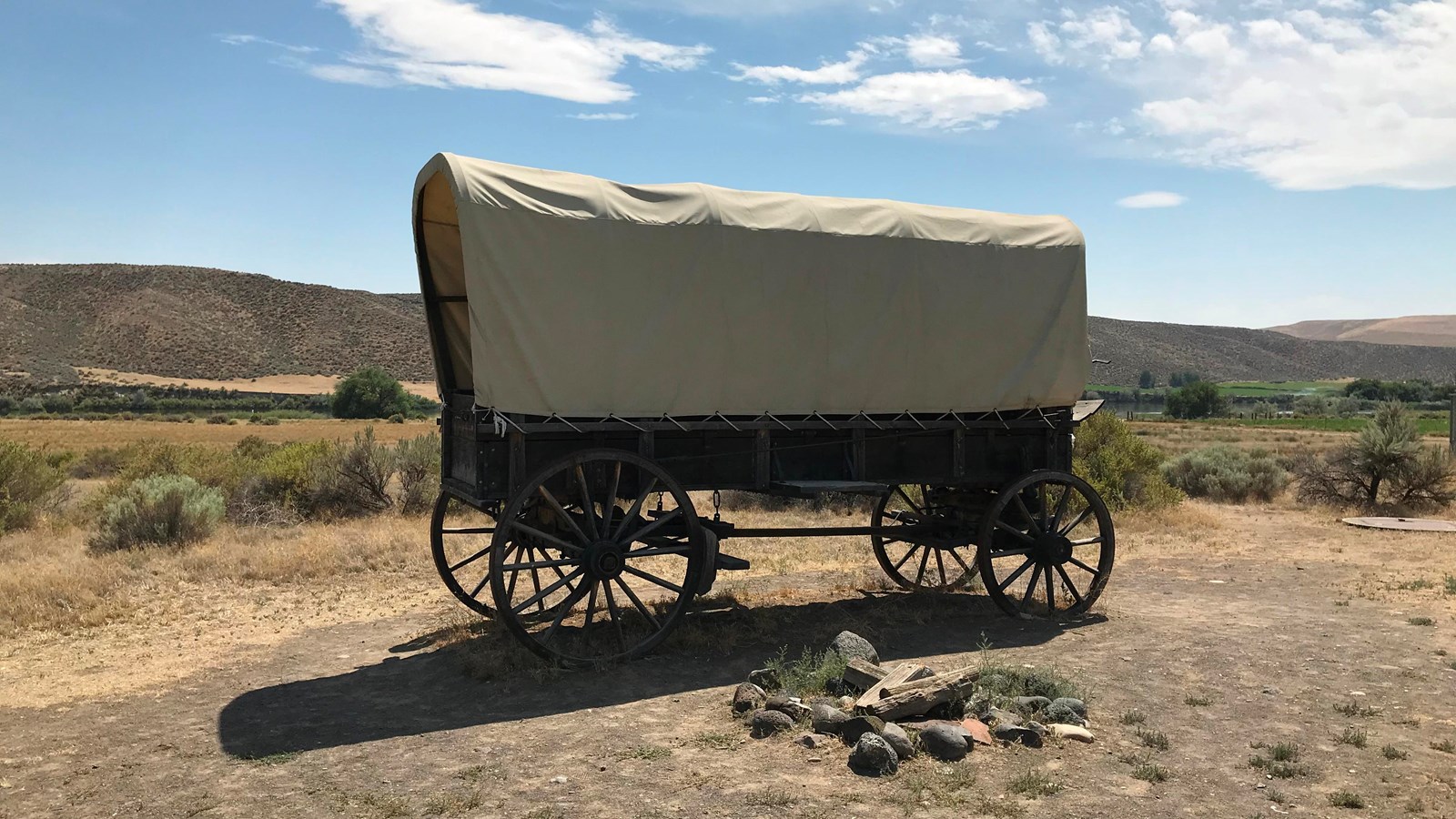 A covered wagon in a desert setting.