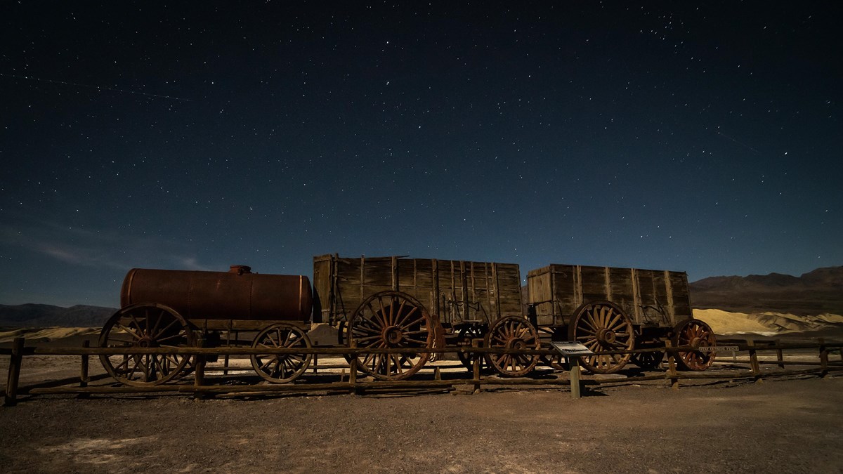 An old wooden wagon train seen at night.