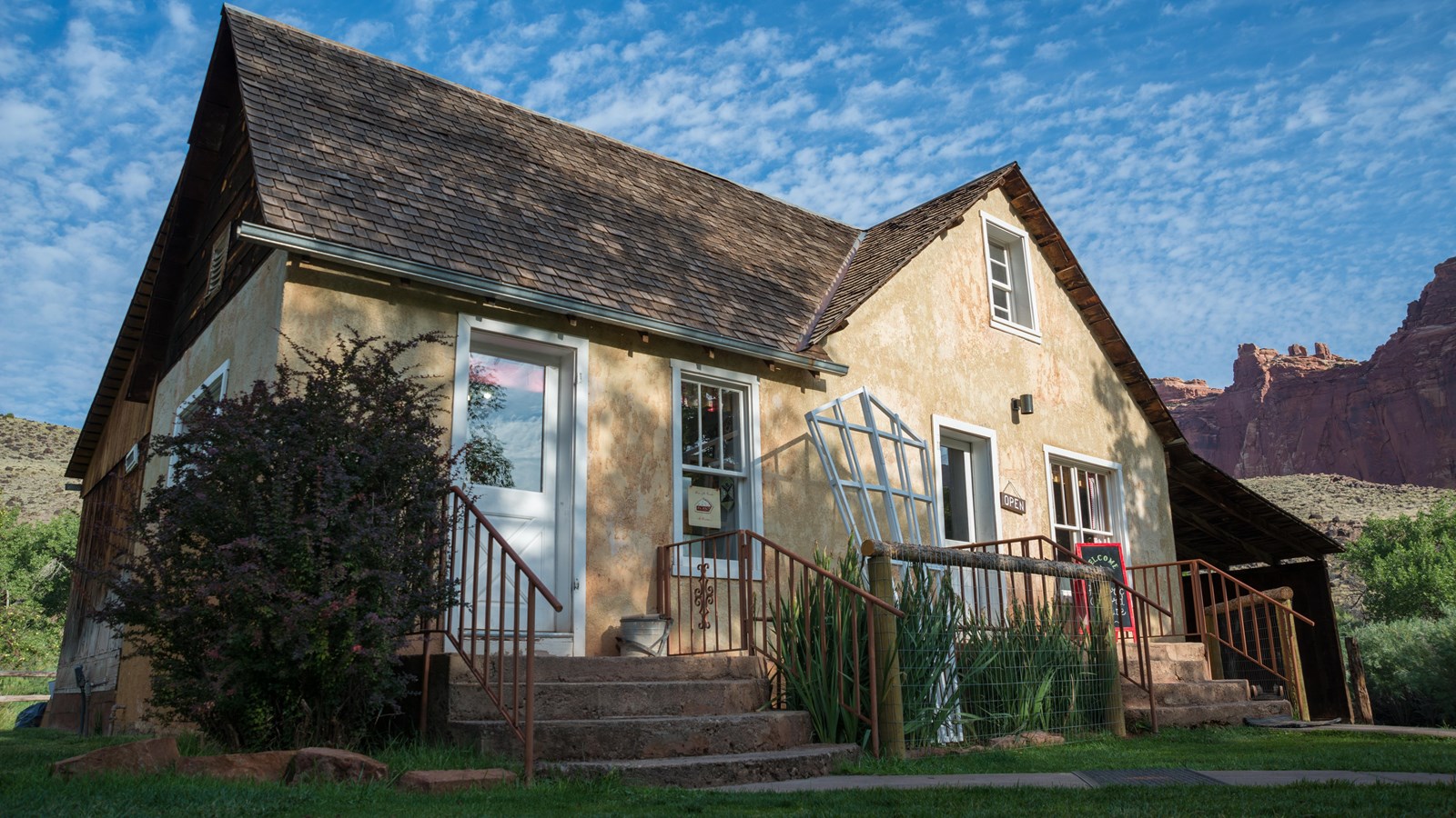 a small farmhouse with two sets of steps each leading up to a door