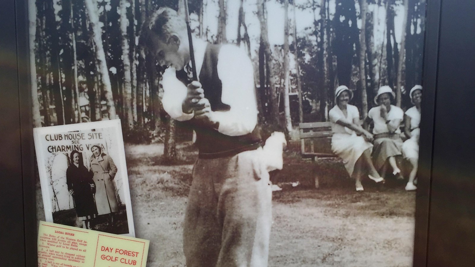 Panel with historic photo of man swinging a golf club while three women in white watch