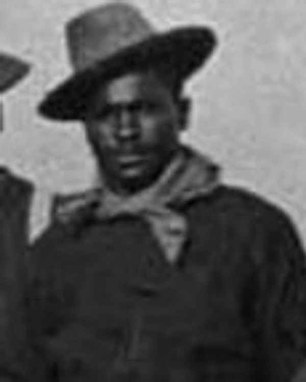 Black and white photo of African American soldier in uniform. White handkerchief around his neck