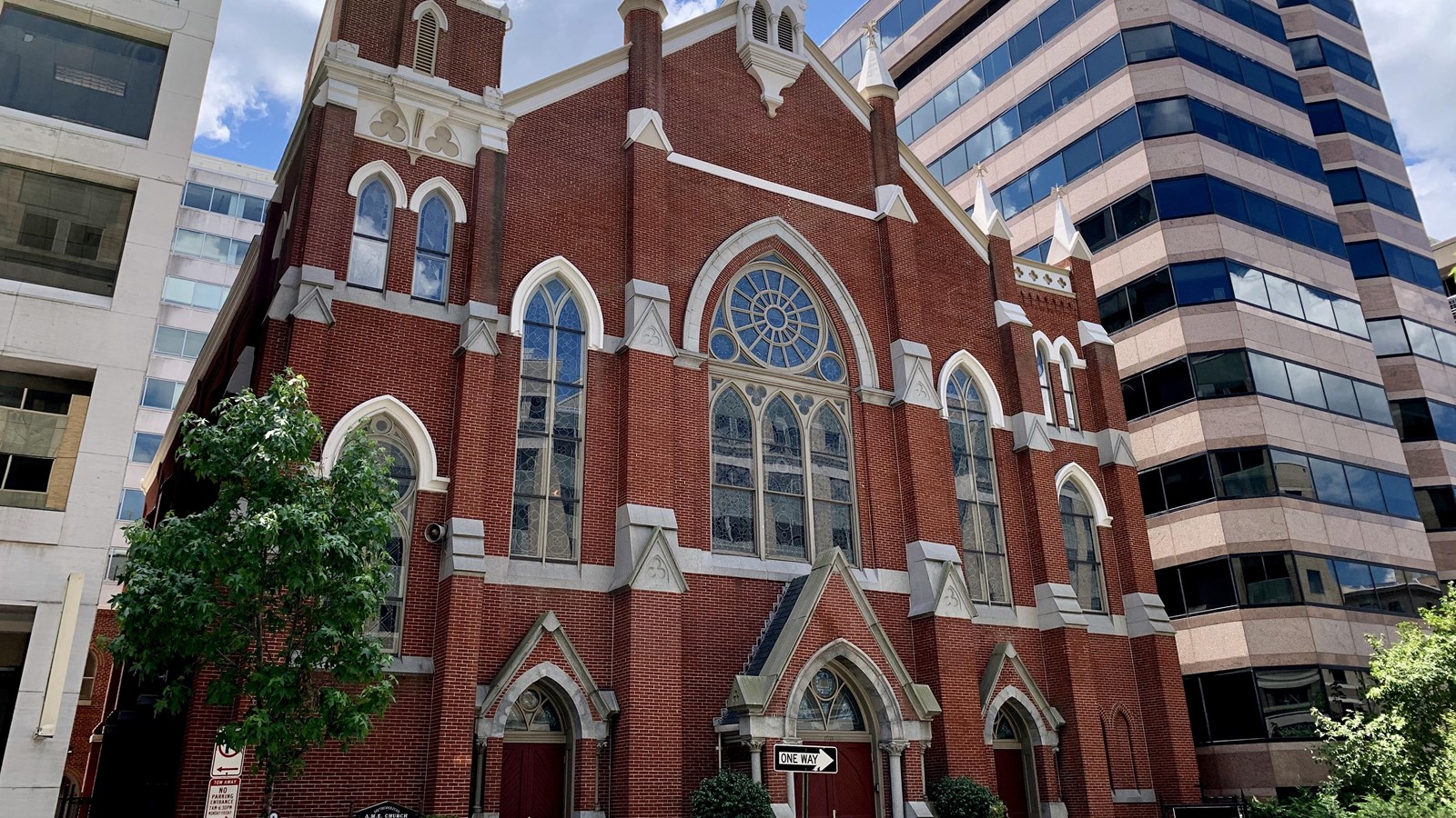 Photo of brick church with stained-glass windows. 