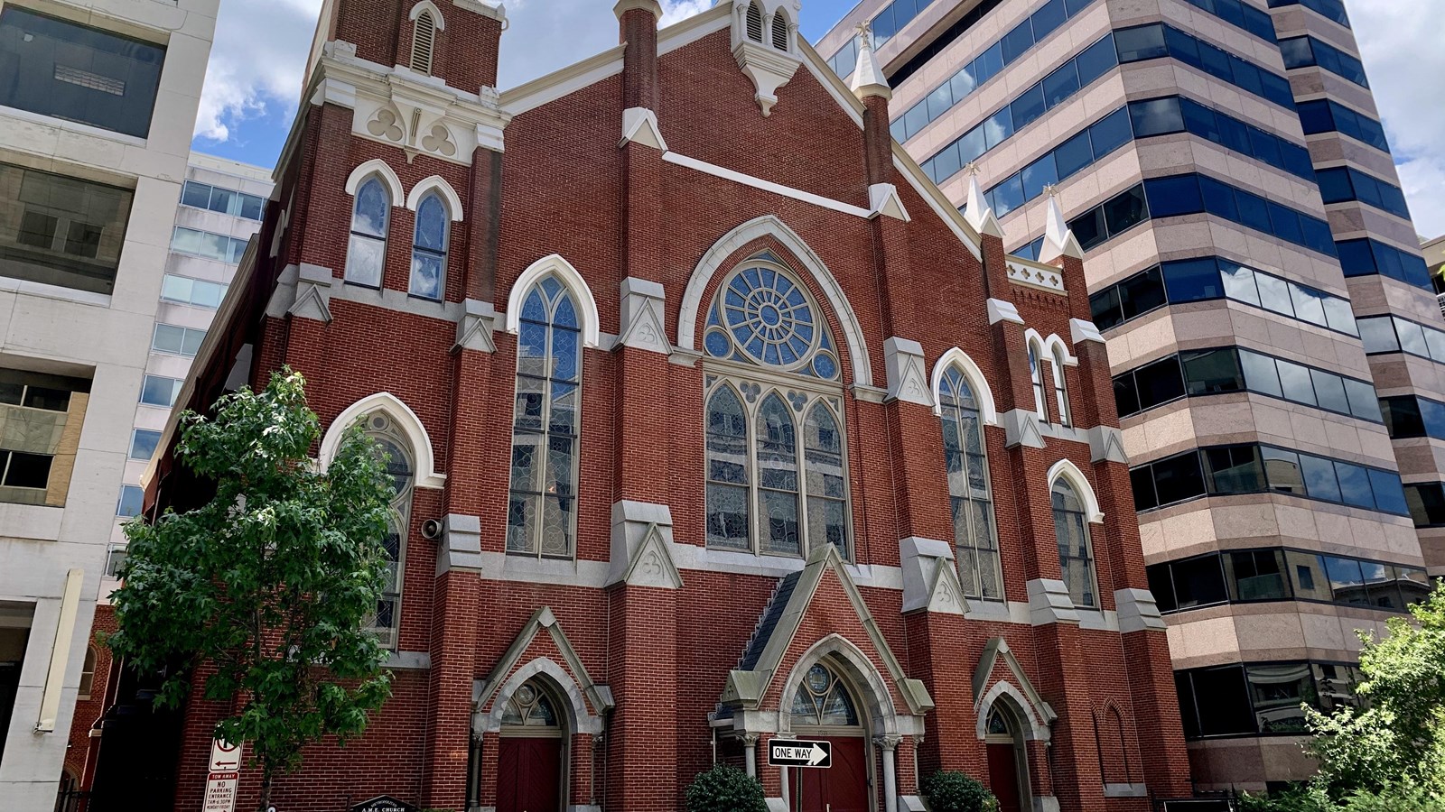 Photo of brick church with stained-glass windows.