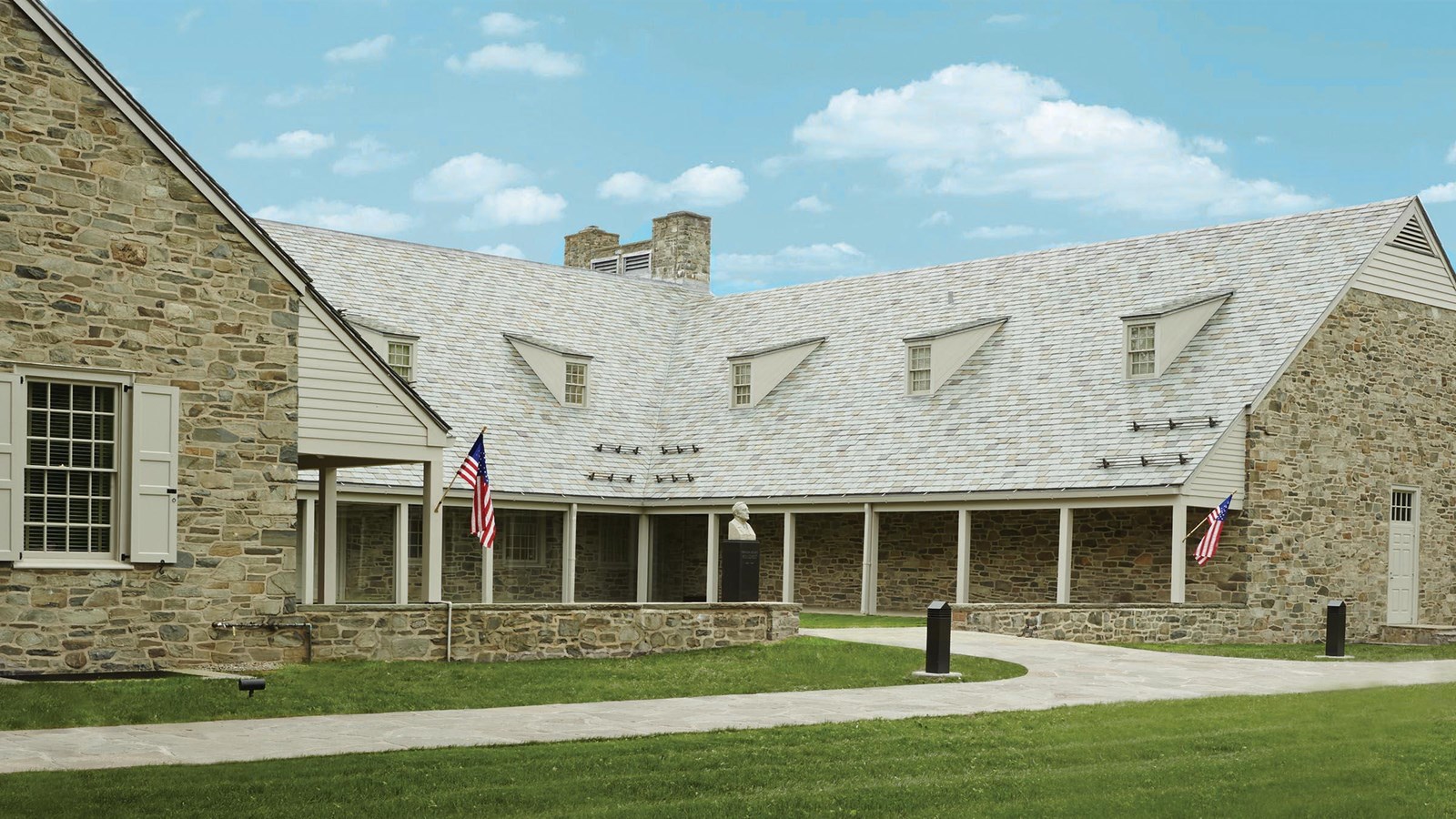 A one-story fieldstone building surrounding a central courtyard.