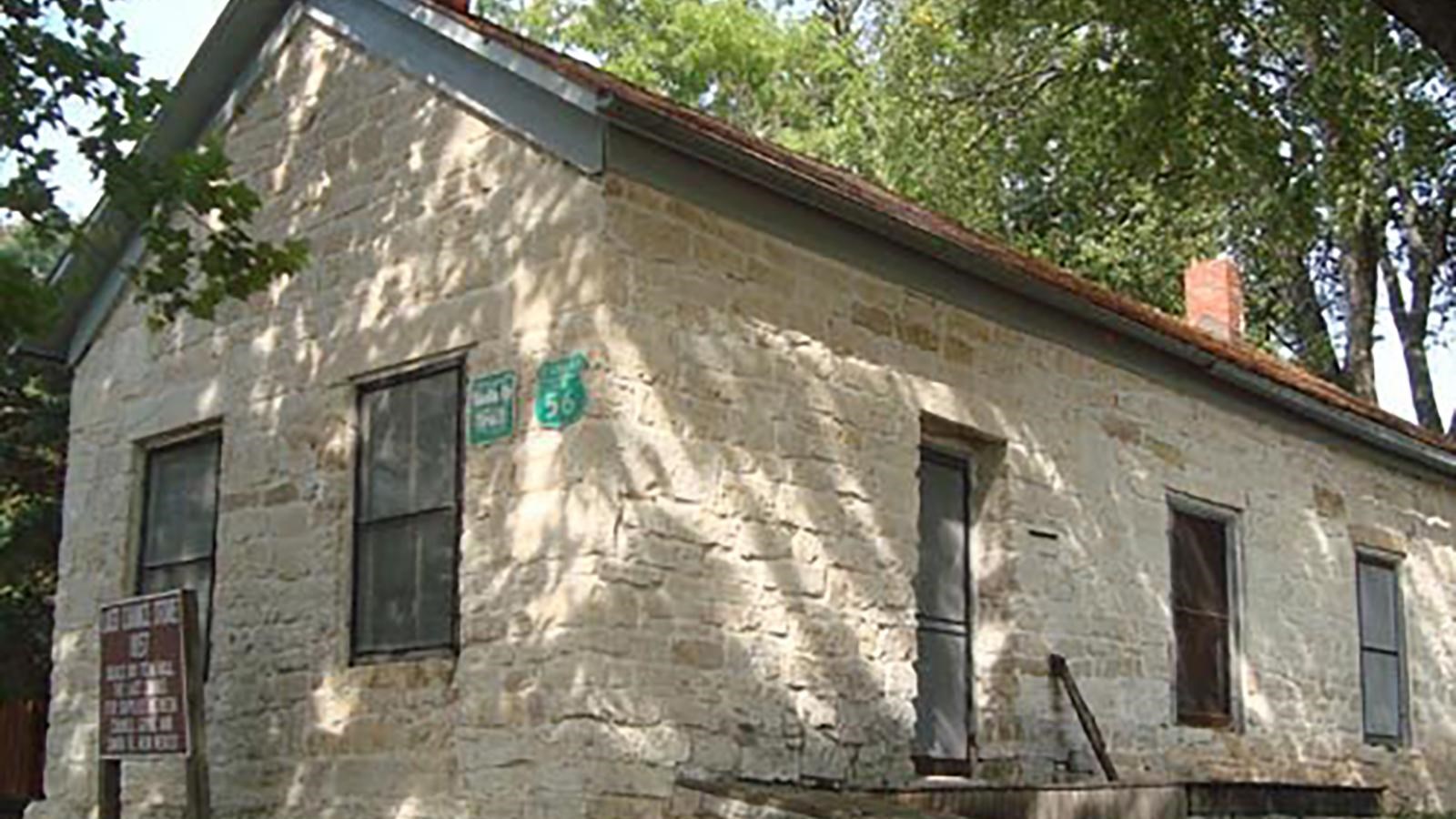 One room stone brick house with a slanting roof.