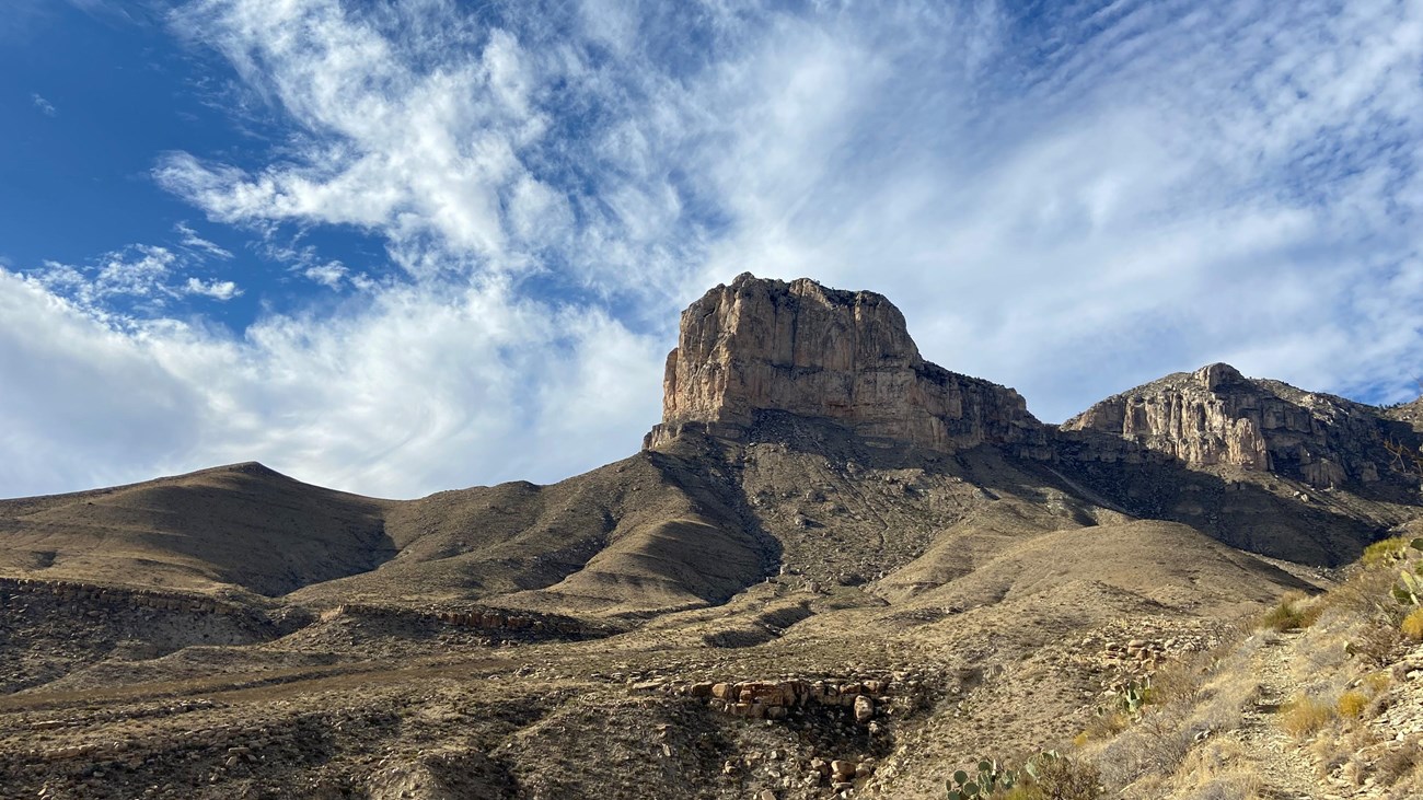 A tall promontory point rises above a desert landscape