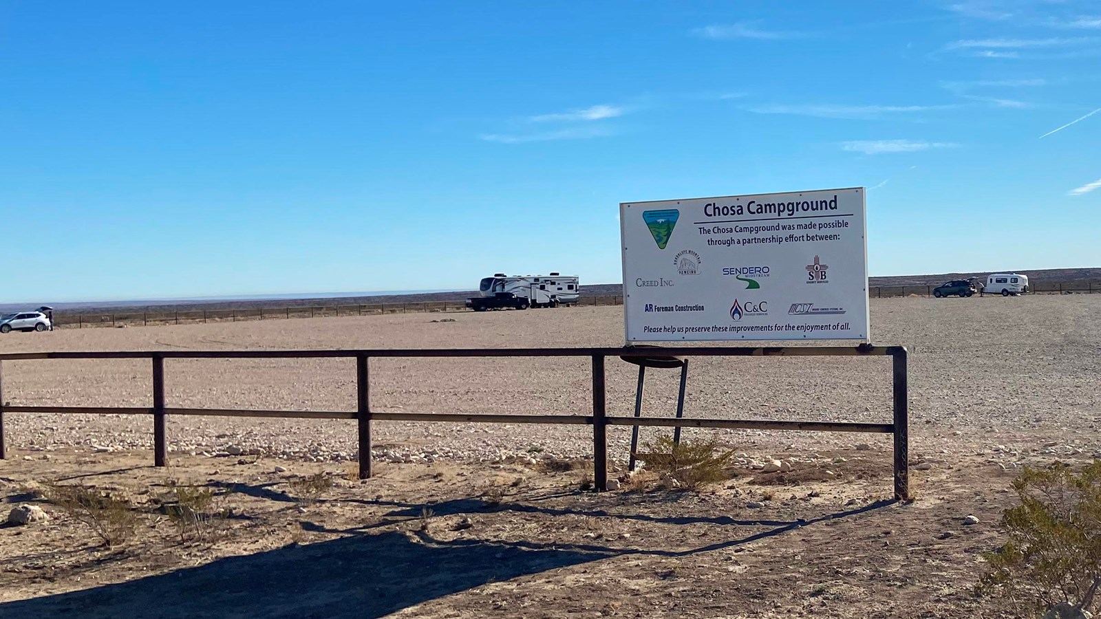 A campground sign and open camping area