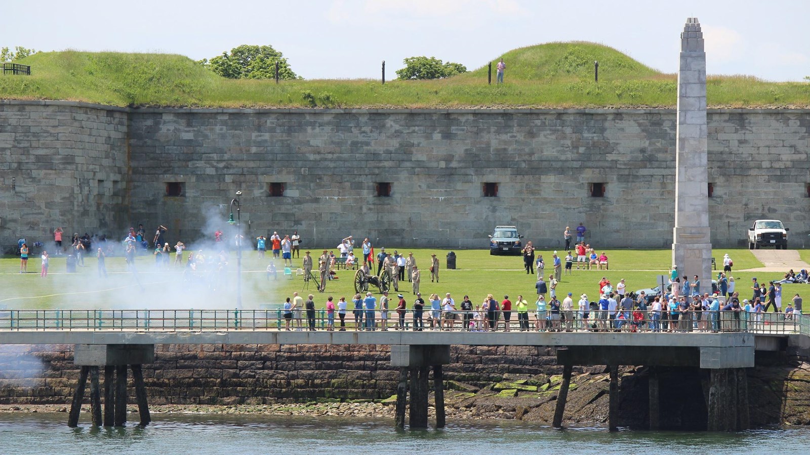 View of portion of a granite fort from the water. The Fort walls is a few floors high.