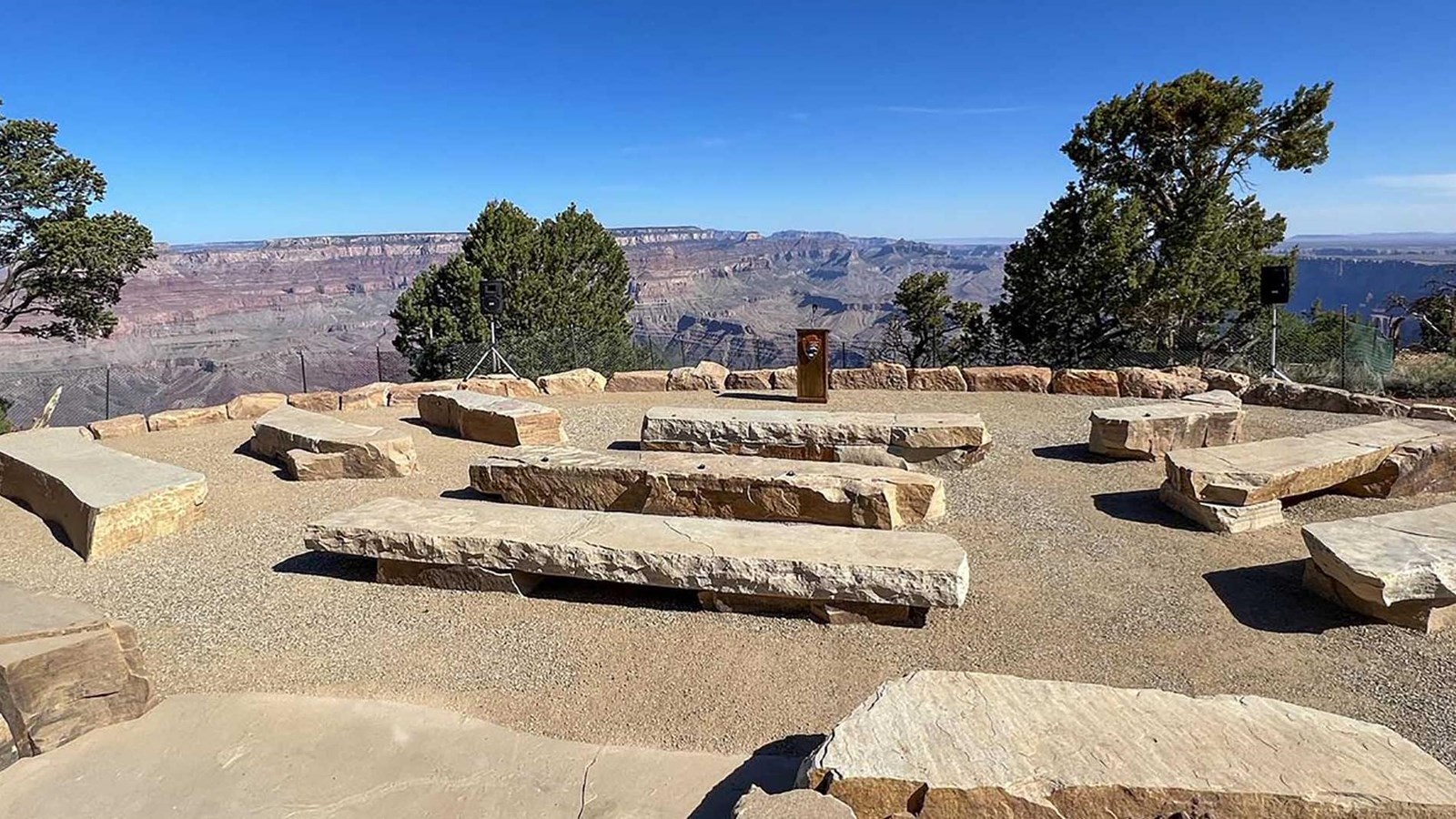 three rows of stone benches overlooking a vast canyon landscape