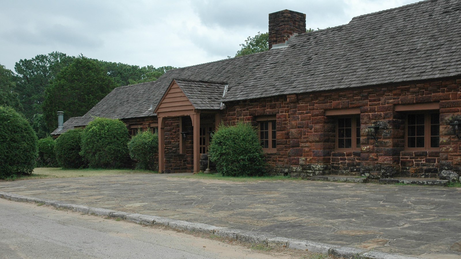 A large brown single-story building with a shingled roof.