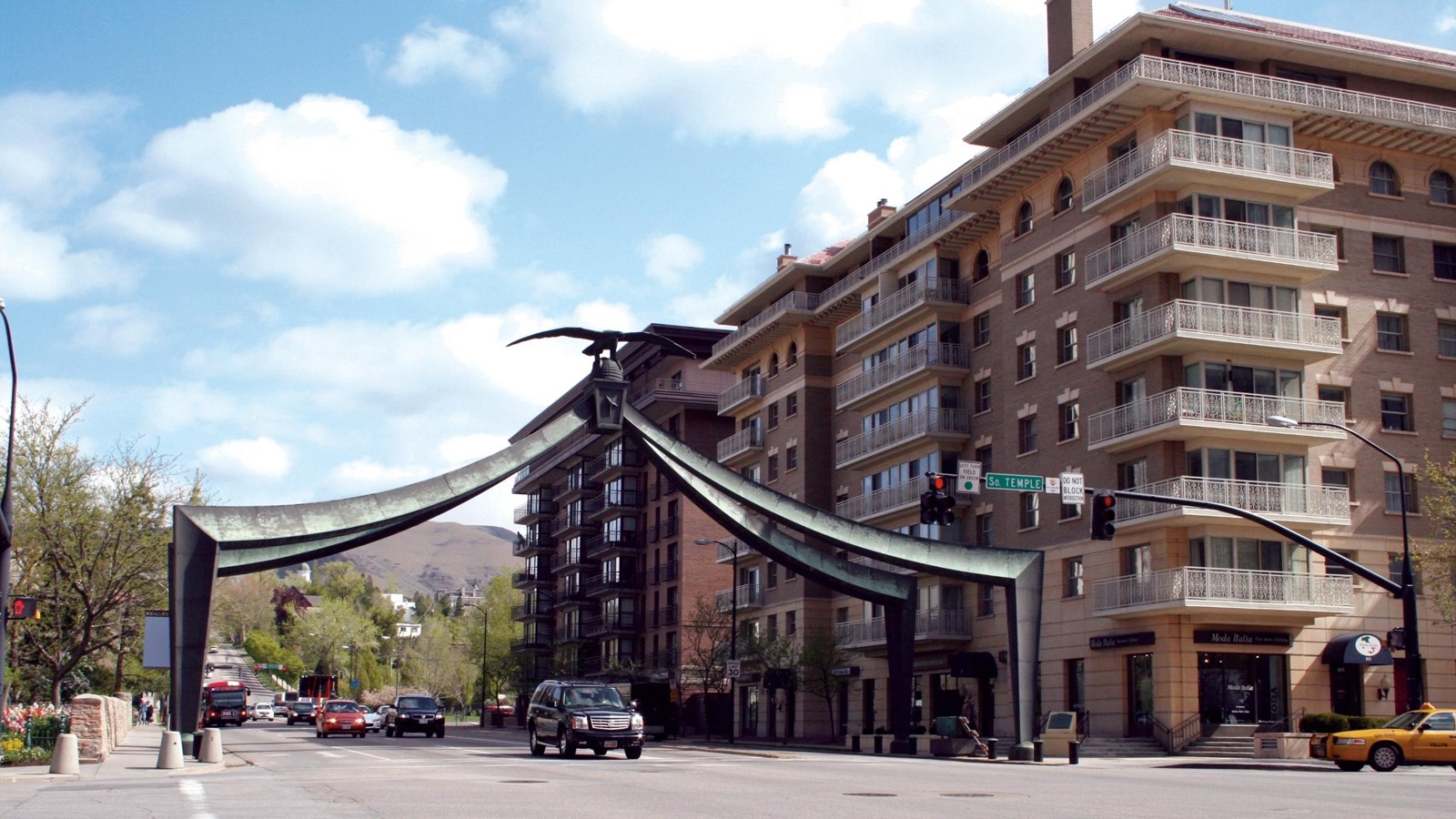 A gate stretches over a city street lined with buildings.