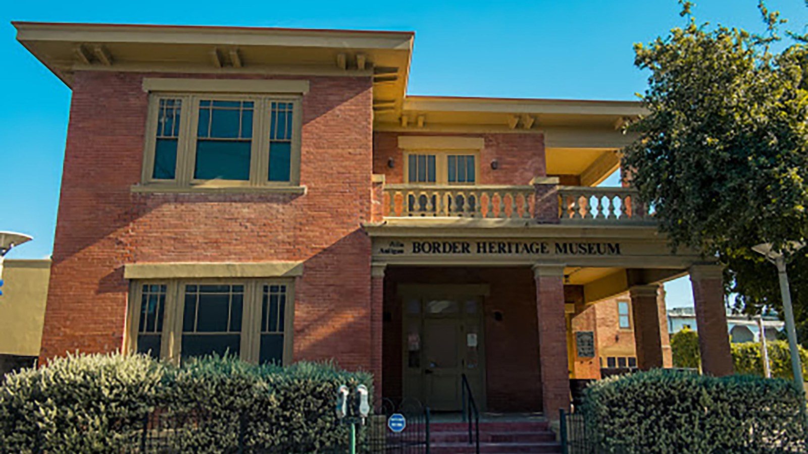 A large two story red brick building with a yellow roof.