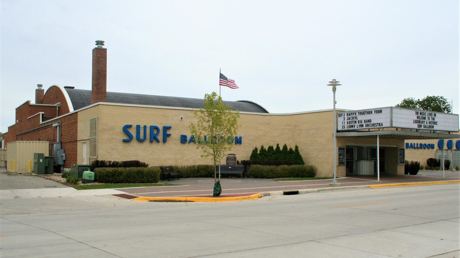 A wide, one-story building with a sign reading Surf Ballroom sits on a street corner.