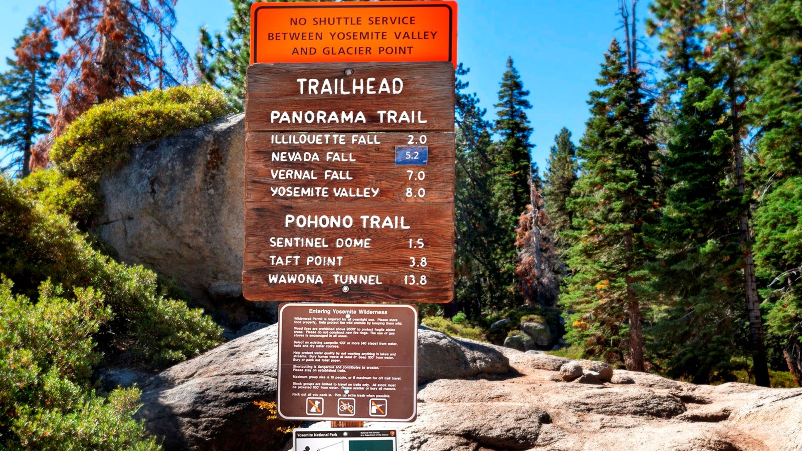 Wooden and metal signs at the trailhead