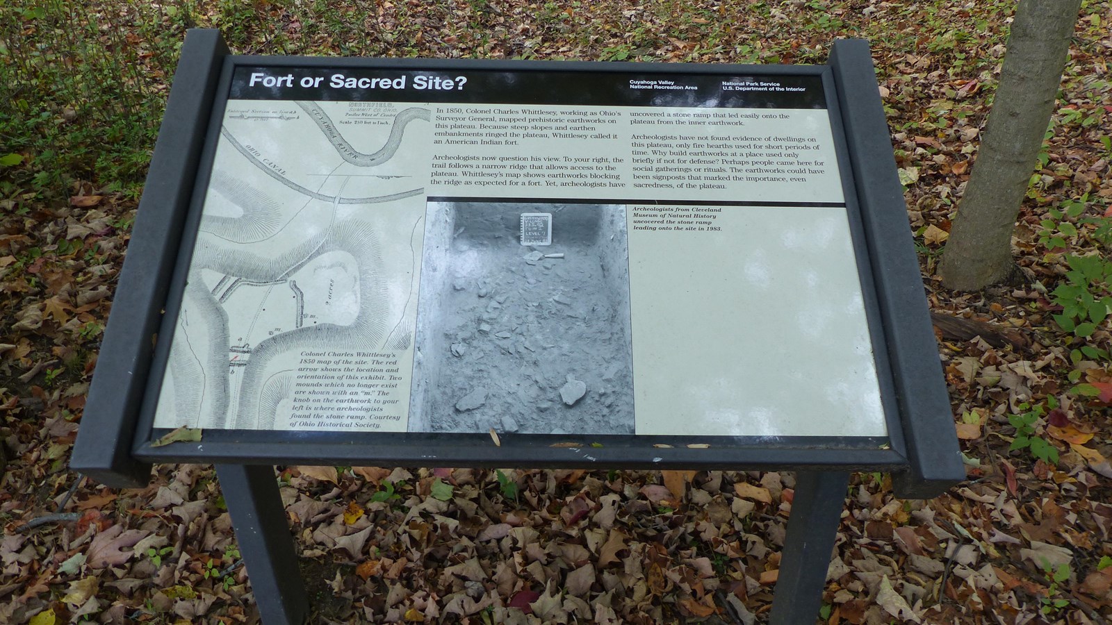 Informational sign in brown metal frame; title reads 